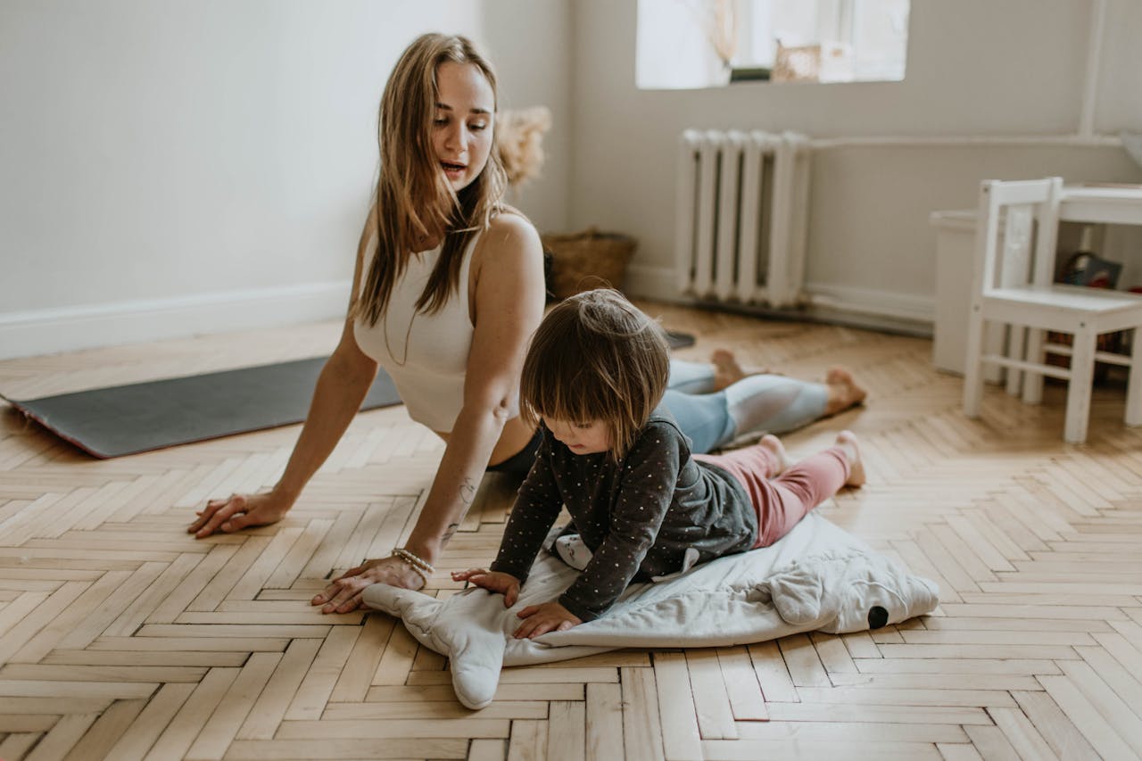 Home A mother and child practicing yoga together at home on a sunny day, fostering wellness and connection.