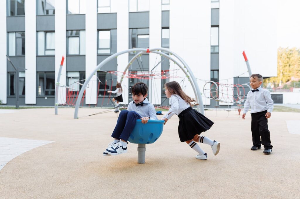 pexels photo 8926833 Joyful children having fun together in a modern outdoor playground area, dressed in formal clothing.